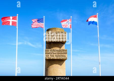 Signaldenkmal in Bernières-sur-Mer, Frankreich, errichtet im Jahr 1950 auf der Anlegestelle der Normandie im Zweiten Weltkrieg am Juno Beach, umgeben von den Flaggen der Alliierten. Stockfoto