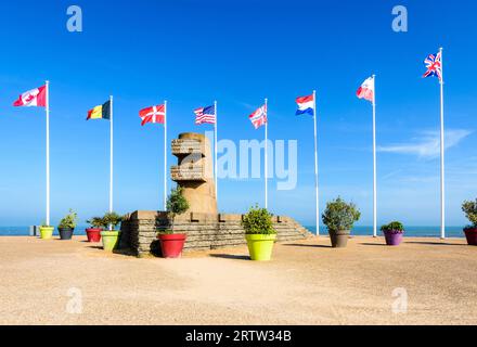 Signaldenkmal in Bernières-sur-Mer, Frankreich, errichtet im Jahr 1950 auf der Anlegestelle der Normandie im Zweiten Weltkrieg am Juno Beach, umgeben von den Flaggen der Alliierten. Stockfoto