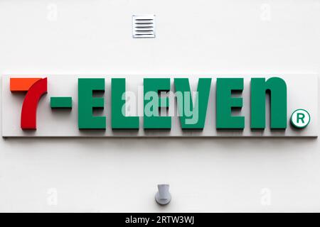 7-Eleven Logo an der Wand. 7-Eleven ist eine internationale Kette von Convenience Stores, die hauptsächlich als Franchise tätig ist Stockfoto