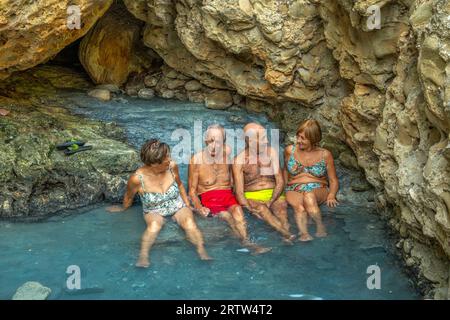 Ältere Menschen und Familien baden in den Thermal- und Schwefelquellen von Lu Vurghe bei Acquasanta Terme. Provinz Ascoli Piceno, Region Marken Stockfoto