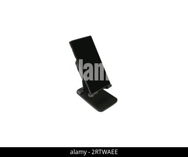 Telefonständer mit schwarzem Smartphone isoliert auf weißem Hintergrund mit Beschneidungspfad. Schwarzes Smartphone mit leerem schwarzem Bildschirm. Stockfoto