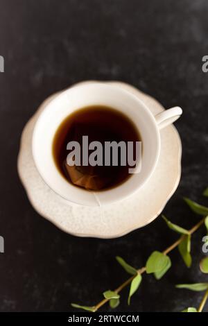 Eine Tasse schwarzer Tee in einer weißen Teetasse Stockfoto