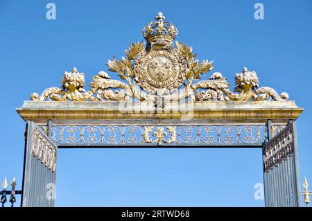 Das wunderschöne Goldene Tor vor dem Schloss von Versailles, unter einem klaren blauen Himmel. Versailles, Frankreich. Stockfoto