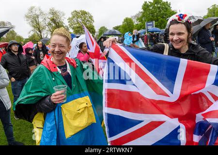 Eine große Menschenmenge, die dem Regen trotzt, um die Krönung von König Karl III. Auf einem riesigen Fernsehbildschirm zu sehen. Hyde Park, London, Großbritannien. 6. Mai 2023 Stockfoto