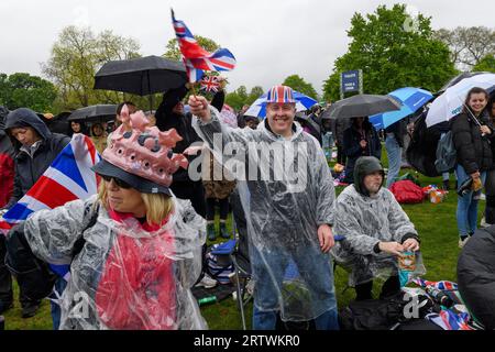 Eine große Menschenmenge, die dem Regen trotzt, um die Krönung von König Karl III. Auf einem riesigen Fernsehbildschirm zu sehen. Hyde Park, London, Großbritannien. 6. Mai 2023 Stockfoto