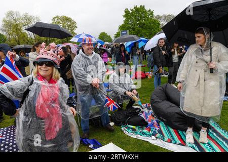 Eine große Menschenmenge, die dem Regen trotzt, um die Krönung von König Karl III. Auf einem riesigen Fernsehbildschirm zu sehen. Hyde Park, London, Großbritannien. 6. Mai 2023 Stockfoto