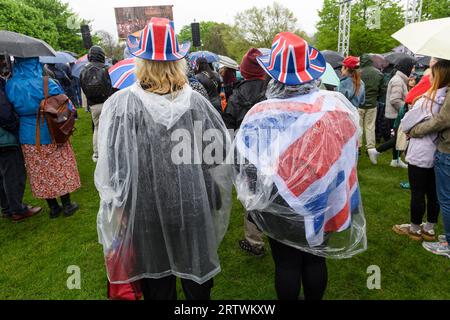 Eine große Menschenmenge, die dem Regen trotzt, um die Krönung von König Karl III. Auf einem riesigen Fernsehbildschirm zu sehen. Hyde Park, London, Großbritannien. 6. Mai 2023 Stockfoto