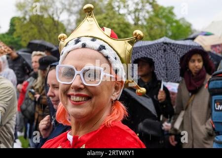 Eine große Menschenmenge, die dem Regen trotzt, um die Krönung von König Karl III. Auf einem riesigen Fernsehbildschirm zu sehen. Hyde Park, London, Großbritannien. 6. Mai 2023 Stockfoto