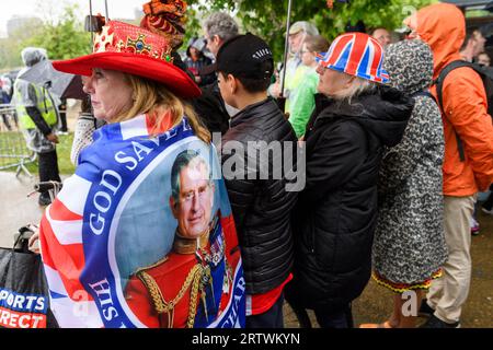 Eine große Menschenmenge, die dem Regen trotzt, um die Krönung von König Karl III. Auf einem riesigen Fernsehbildschirm zu sehen. Hyde Park, London, Großbritannien. 6. Mai 2023 Stockfoto