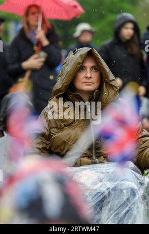 Eine große Menschenmenge, die dem Regen trotzt, um die Krönung von König Karl III. Auf einem riesigen Fernsehbildschirm zu sehen. Hyde Park, London, Großbritannien. 6. Mai 2023 Stockfoto