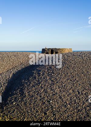 Eine aus dem Zweiten Weltkrieg stammende Pillenschachtel auf dem Kiesrücken am Bossington Beach in Porlock Bay, Exmoor National Park, Somerset, England. Stockfoto