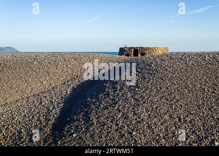 Eine aus dem Zweiten Weltkrieg stammende Pillenschachtel auf dem Kiesrücken am Bossington Beach in Porlock Bay, Exmoor National Park, Somerset, England. Stockfoto