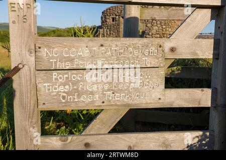 Ein Schild an einem Tor bei Porlock Marsh warnt, dass es keinen Küstenpfad vor sich gibt, da der Kieselgrat im Exmoor National Park, Somerset, England, durchbrochen ist. Stockfoto