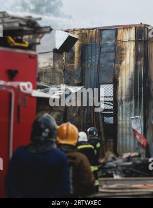 Massive Großbrände in der Stadt, brennende Lagerfabrik, Lagergebäude brennt, Feuerwehrteam, Feuerwehrleute im Dienst, Stockfoto