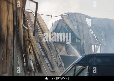 Massive Großbrände in der Stadt, brennende Lagerfabrik, Lagergebäude brennt, Feuerwehrteam, Feuerwehrleute im Dienst, Stockfoto