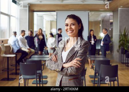 Porträt einer erfolgreichen jungen Geschäftsfrau, die mit selbstbewusstem Ausdruck in die Kamera schaut. Stockfoto