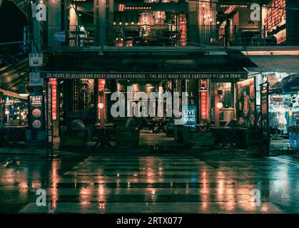 Eine nasse Nacht bringt die Farbe in den Straßen von Siem Reap zum Ausdruck. Die Lichter von Bars und Restaurants spiegeln sich auf den Straßen wider. Ein Fußgängerkreuz Stockfoto