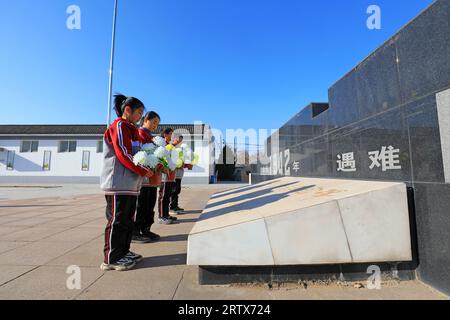 LUANNAN COUNTY, China - 13. Dezember 2021: Die Studenten präsentierten dem Denkmal in Nordchina Blumen Stockfoto