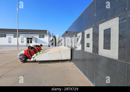 LUANNAN COUNTY, China - 13. Dezember 2021: Die Studenten präsentierten dem Denkmal in Nordchina Blumen Stockfoto