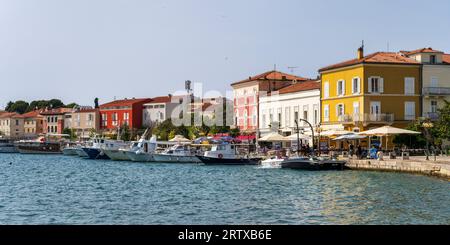 Panoramablick auf farbenfrohe Gebäude und Boote am Ufer von Poreč, einem beliebten Sommerresort, auf der istrischen Halbinsel von Kroatien Stockfoto