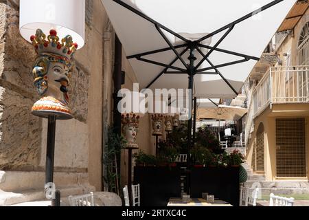 Essen im Freien in einem Restaurant oder Café in Taormina, Sizilien. Dekorative Lampen und Tische zum Essen Stockfoto