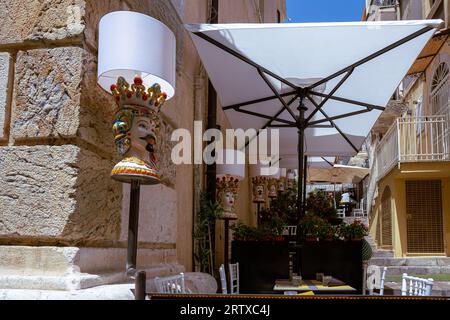 Essen im Freien in einem Restaurant oder Café in Taormina, Sizilien. Dekorative Lampen und Tische zum Essen Stockfoto