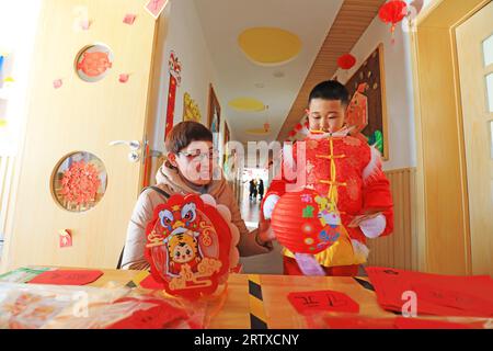 LUANNAN COUNTY, China - 31. Dezember 2021: Ein Kind und seine Mutter wählten gemeinsam Laternen aus, Nordchina Stockfoto