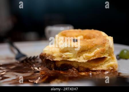 Sluffy Souffle Pfannkuchen Dessert mit Schokoladeneis serviert auf einem weißen Teller auf einem Holztisch Stockfoto