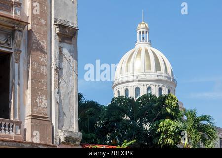 Havanna, Kuba, 2023, die goldfarbene Kuppel des Capitolio-Gebäudes steht im Kontrast zu einem verwitterten Wohnhaus. Stockfoto