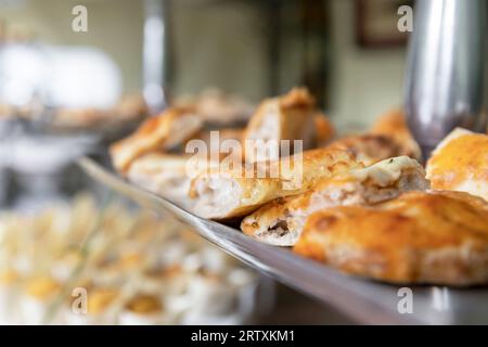 Nahaufnahme mit Focaccia-Brotscheiben und Pizza. Hausgemachte Focaccia und Pizza als Vorspeise. Party. Veranstaltung. Defokussierter Hintergrund. Stockfoto