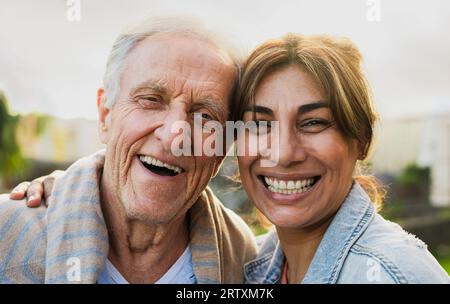 Glückliche Freunde mit unterschiedlichem Alter und ethnischer Zugehörigkeit, die vor einer Kamera lächeln Stockfoto