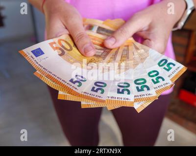 Nahaufnahme von Händen, die 50 Euro-Banknoten in bar halten Stockfoto