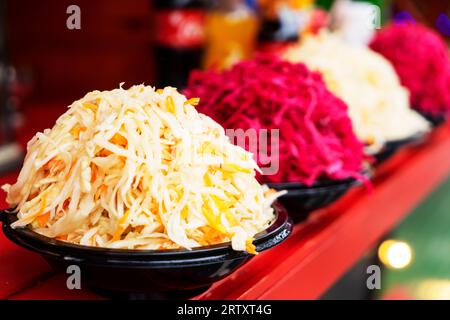 Weiße, rote, gesalzene Sauerkrautsalatplatten auf der Ladentheke Stockfoto