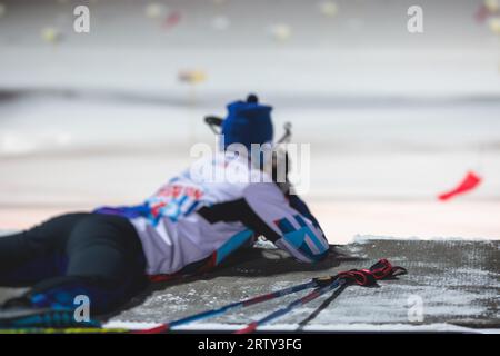 Biathlet mit Gewehr auf einem Schießstand während des Biathlontrainings, Skifahrer auf dem Trainingsgelände im Winterschnee, Athleten nehmen an Biathlonwettbewerben Teil Stockfoto