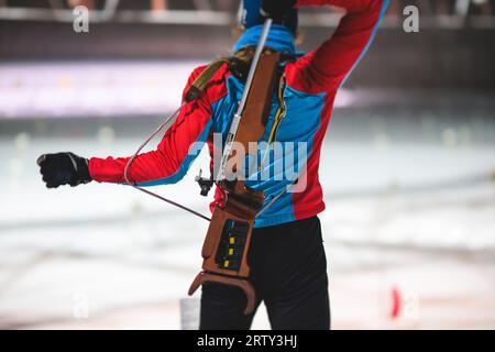 Biathlet mit Gewehr auf einem Schießstand während des Biathlontrainings, Skifahrer auf dem Trainingsgelände im Winterschnee, Athleten nehmen an Biathlonwettbewerben Teil Stockfoto