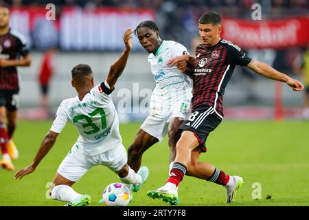 Nürnberg, Deutschland. September 2023. Fußball: 2. Bundesliga, 1. FC Nürnberg - SpVgg Greuther Fürth, Spieltag 6, Max-Morlock-Stadion. Fürths Julian Green (l-r) und Dickson Abiama kämpfen um den Ball mit Nürnbergs Taylan Duman. Kredit: Daniel Löb/dpa – WICHTIGER HINWEIS: gemäß den Anforderungen der DFL Deutsche Fußball Liga und des DFB Deutscher Fußball-Bund ist es untersagt, im Stadion und/oder im Spiel aufgenommene Fotografien in Form von Sequenzbildern und/oder videoähnlichen Fotoserien zu nutzen oder nutzen zu lassen./dpa/Alamy Live News Stockfoto