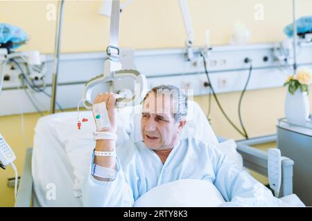 Männlicher Patient nach Verletzung oder Operation auf der Krankenhausstation Stockfoto