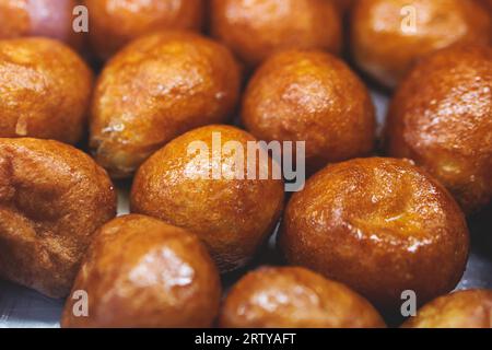 Aus nächster Nähe sehen Sie Loukoumades Dessert, griechische Donuts mit Honig und Walnuss, traditionelle griechische Lokma Süßigkeiten Gebäck und Köstlichkeiten, die in einem Bäckercafé serviert werden Stockfoto