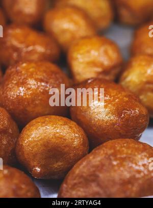 Aus nächster Nähe sehen Sie Loukoumades Dessert, griechische Donuts mit Honig und Walnuss, traditionelle griechische Lokma Süßigkeiten Gebäck und Köstlichkeiten, die in einem Bäckercafé serviert werden Stockfoto