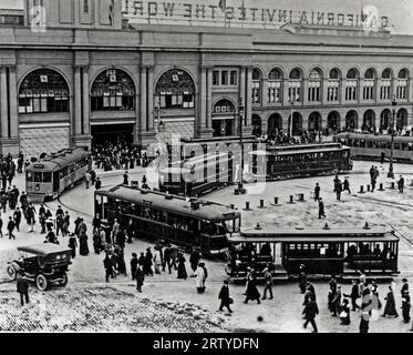 San Francisco, Kalifornien 1915 Straßenbahnen und Cable Cars am Embarcadero Turn Aroound bieten Besuchern der Panama-Pacific International Exposition als „California Invads the World“ Transport, wie auf der Rückseite auf der Spitze des Ferry Building zu sehen Stockfoto