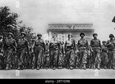 Paris, Frankreich, 29. August 1944 Soldaten der United States Army marschieren die Champs-Elysées hinunter, nachdem sie den Arc de Triomphe während der Befreiungsparade von Paris durchquerten. Stockfoto