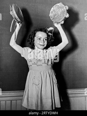 Ottawa, Kanada, ca. 1950 Ein junges Mädchen in einer Rhythmusband spielt Tambourines beim Canadian Music Festival. Stockfoto