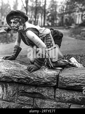 Tarrytown-on-Hudson, New York November 1925 es ist „Dog Week“ an der Highland Manor School, wo jeder Senior einen Junior für seinen Hund haben soll. Bevor sie sich an ihren „Meister“ wendet, muss jeder Hund auf die Knie fallen und bellen. Dieser Hund genießt ihr Mittagessen, ein großzügiges Fleischknochen. Stockfoto