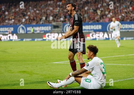 Nürnberg, Deutschland. September 2023. Fußball: 2. Bundesliga, 1. FC Nürnberg - SpVgg Greuther Fürth, Spieltag 6, Max-Morlock-Stadion. Nürnbergs Ivan Marquez (l) feiert neben Fürths Armindo Sieb einen erfolgreichen Schachzug. Kredit: Daniel Löb/dpa – WICHTIGER HINWEIS: gemäß den Anforderungen der DFL Deutsche Fußball Liga und des DFB Deutscher Fußball-Bund ist es untersagt, im Stadion und/oder im Spiel aufgenommene Fotografien in Form von Sequenzbildern und/oder videoähnlichen Fotoserien zu nutzen oder nutzen zu lassen./dpa/Alamy Live News Stockfoto