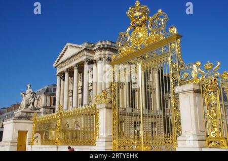 Das wunderschöne Goldene Tor vor dem Schloss von Versailles, unter einem klaren blauen Himmel. Versailles, Frankreich. Stockfoto