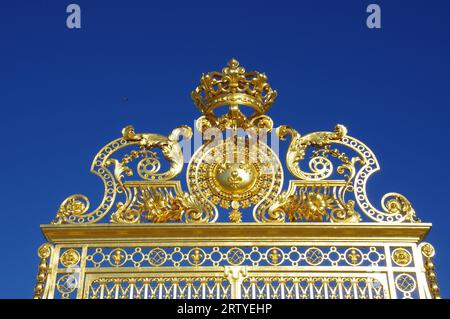 Das wunderschöne Goldene Tor vor dem Schloss von Versailles, unter einem klaren blauen Himmel. Versailles, Frankreich. Stockfoto