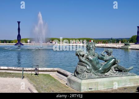 Statue von Neptun an einem Brunnen in den Gärten des Schlosses von Versailles. Blaues Kunstwerk von Joana Vasconcelos. Versailles, Frankreich Stockfoto