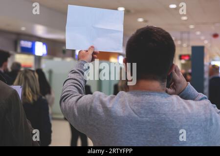Treffen am Flughafen, Person mit einem Plakatkartenschild mit Begrüßungstext, Begrüßung des Passagiers bei der Ankunft, mit einem Namensschild zur Begrüßung von trave Stockfoto