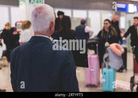 Treffen am Flughafen, Person mit einem Plakatkartenschild mit Begrüßungstext, Begrüßung des Passagiers bei der Ankunft, mit einem Namensschild zur Begrüßung von trave Stockfoto