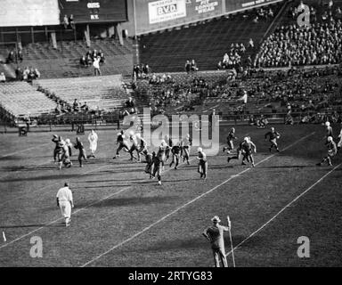 New York, New York: c. 1915 der Quarterback ganz links wird von Verteidigern überschwemmt, wenn er versucht, den Football während eines Spiels im Yankee Stadium zu bestehen. Stockfoto